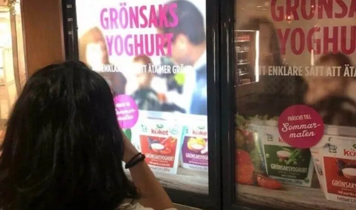 Person tar foto på matreklam