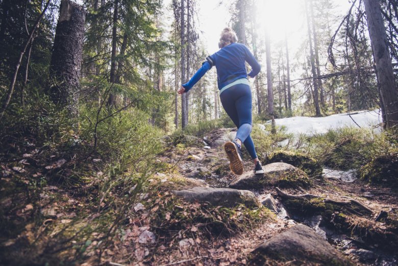 Kvinna springer i skogen