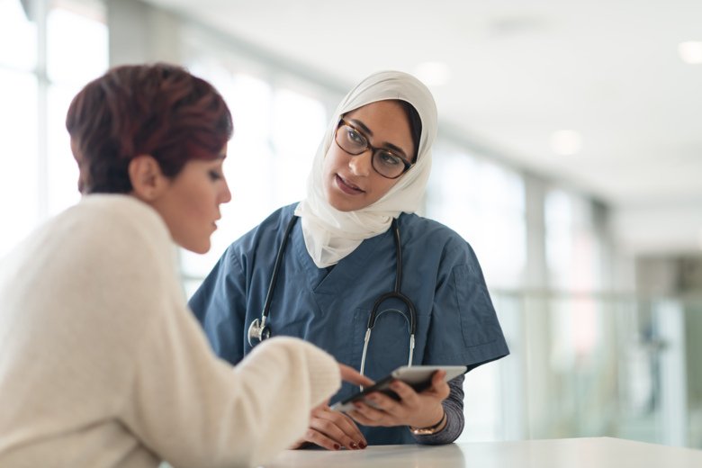 Photo of doctor advising patient using a tablet.