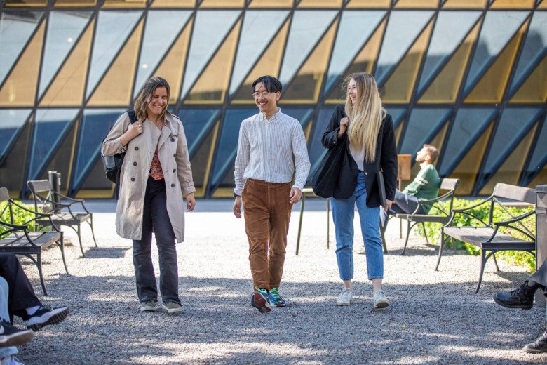 Tre studenter går från campus. Aula medica syns i bakgrunden.