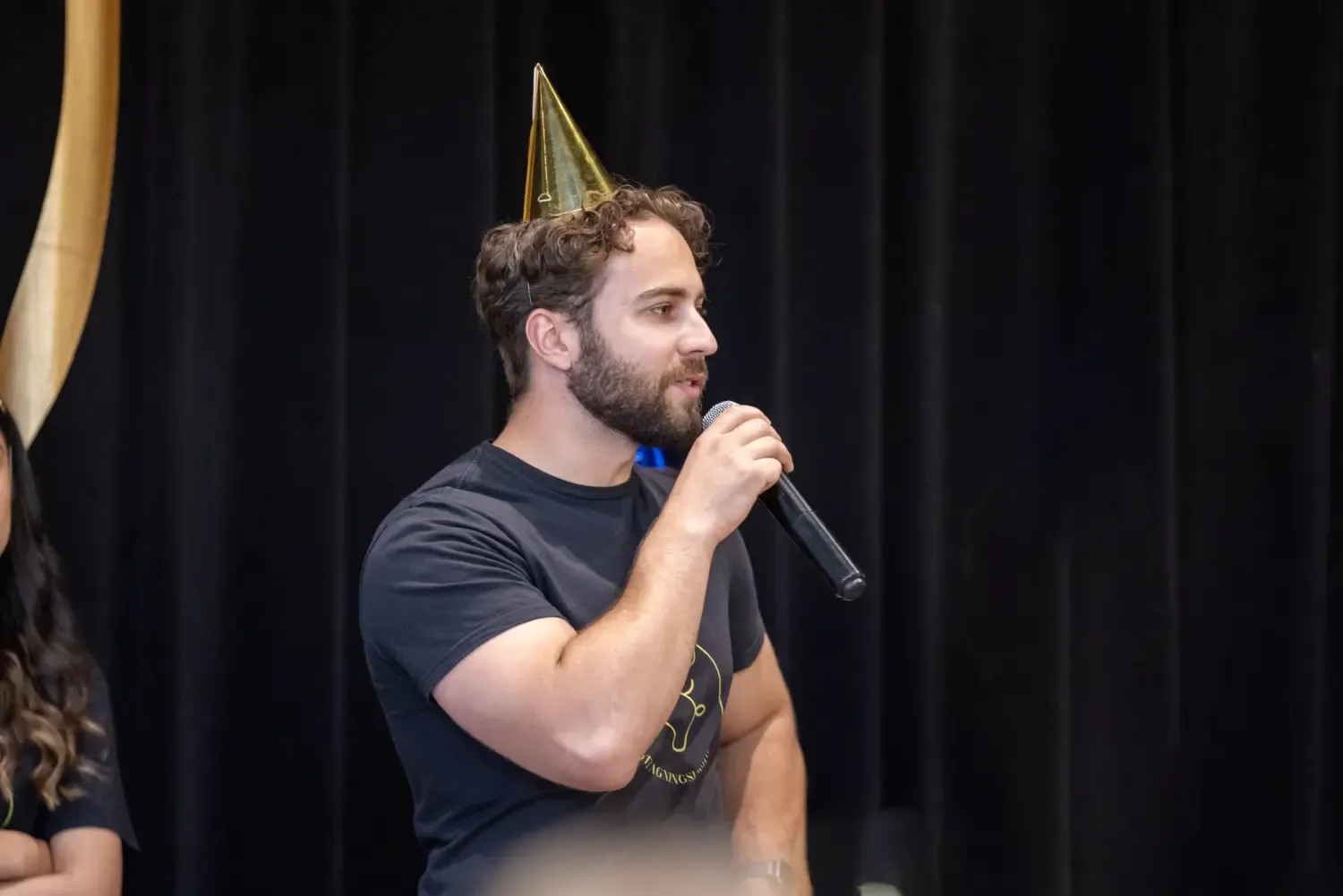 Studenten Artem står på en scen och pratar in i en mikrofon.