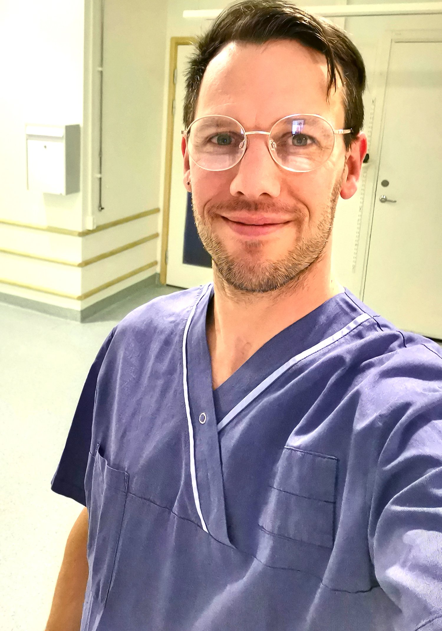 Manlig student iklädd arbetskläder som tittar in i kameran