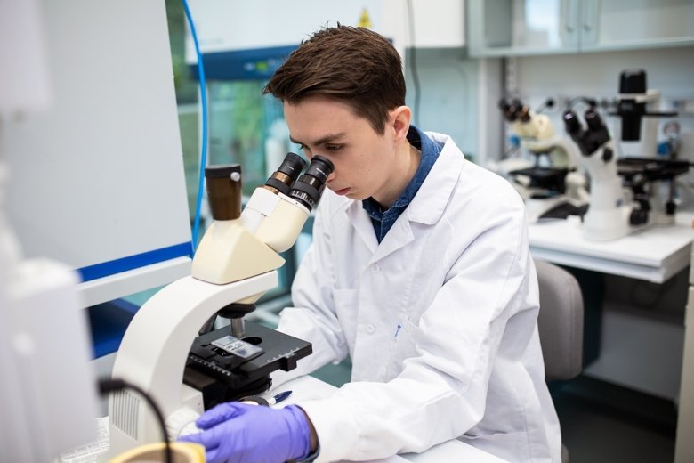 biomedicinsk analytikerstudent tittar i mikroskop