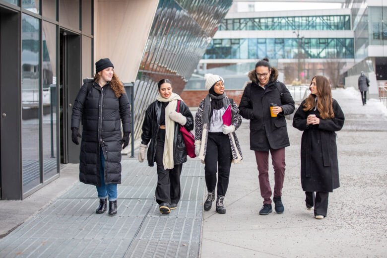 Studenter som promenerar vid Aula medica på ett vintrigt campus Solna
