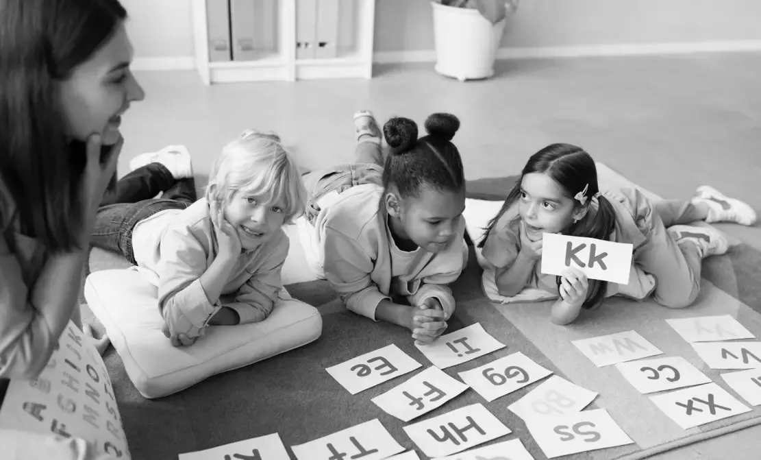 Barn och en lärare med bokstäver.