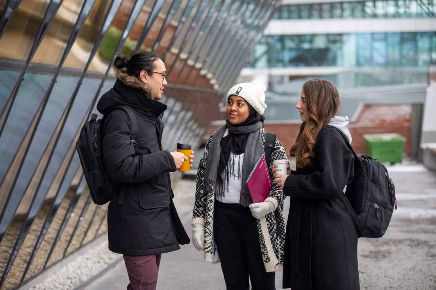 Studenter utomhus på campus Solna en snöig vinterdag.