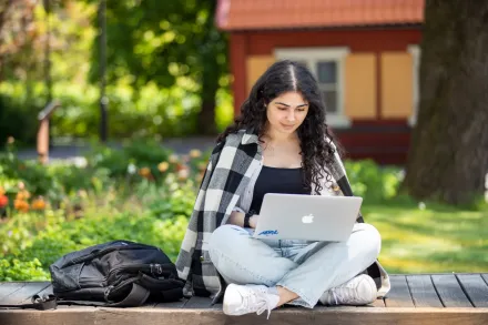 Studenter utomhus på campus Solna en solig vårdag 2022.