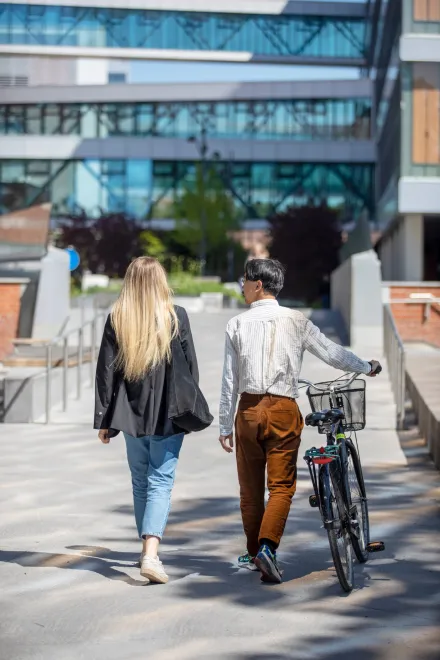 Studenter utomhus på campus Solna en solig vårdag 2022.