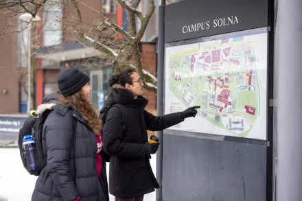 Studenter utomhus på campus Solna en snöig vinterdag.